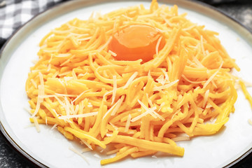 Plate with tasty pasta, cheese and egg, closeup