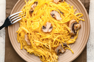 Plate with tasty pasta and mushrooms on table