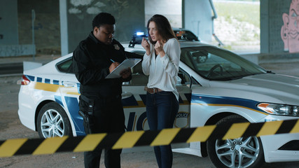 Close up policeman interrogates a woman in an incident arrest criminal enforcement burglar man...