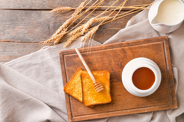 Sweet honey, milk and toasted bread on table