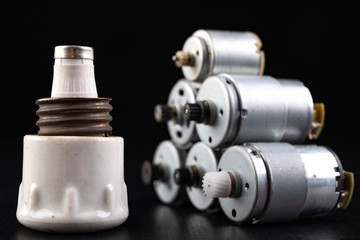 Small electric motor and ceramic fuse. Electrical accessories in the mechanic's workshop.