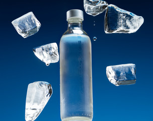 Bottle of cold drinking water and pieces of ice