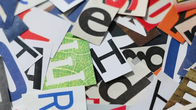Rotating letters cut from magazines - abstract background