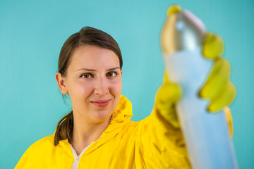 Portrait of a woman in a yellow suit in yellow gloves with a spray or air freshener. Isolate Insect protection