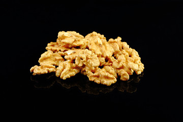 Walnuts with yellow autumn leaves isolated on black background