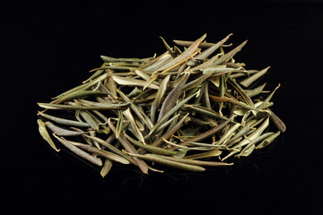 Real olive green fallen leaves, isolated on black background, close-up flat lay top view.