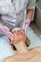 Obraz na płótnie Canvas Beautician makes a procedure for a girl to improve facial skin condition