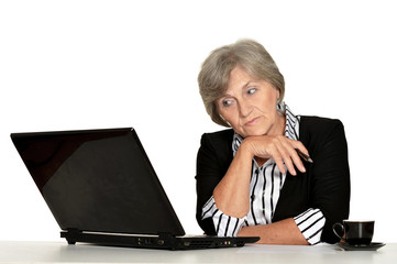 Elderly woman working with laptop on white background