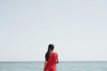 Fototapeta na wymiar woman in red dress on the beach