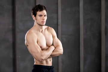 Muscular young man in a studio. Portrait of strong brutal guy.