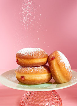Powdered sugar falling on donuts on plate