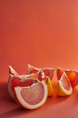 fresh pink grapefruit pieces on orange background,front view vertical