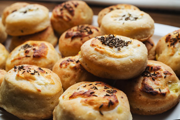 Homemade Cheese Scones with Caraway meridian fennel Persian cumin egg glazed baked buns in a plate fresh close up