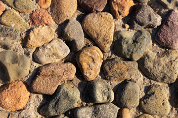 Background of colored stones. The surface is decorated with natural material. Pattern on the floor of multicolored pebbles.