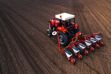 Zelfklevend Fotobehang Tractor Aerial view of tractor with mounted seeder performing direct seeding