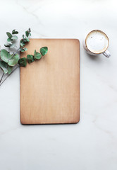 Office desk with Clipboard wood mockup , coffe cup and eucalyptus leaves.