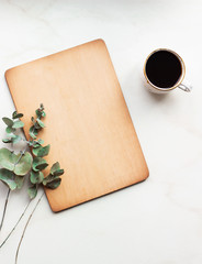 Office desk with Clipboard wood mockup , coffe cup and eucalyptus leaves.