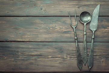 Stylized cutlery on rustic table top view with copy space, local food concept.