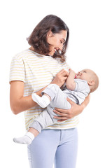 Mother feeding baby with milk from bottle on white background