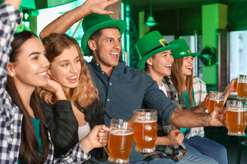 Young friends celebrating St. Patrick's Day in pub