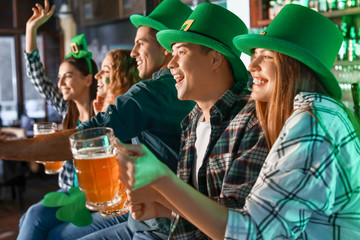 Young friends celebrating St. Patrick's Day in pub