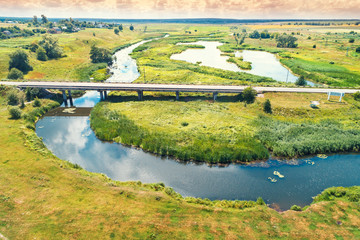 Fototapeta premium Summer rural landscape. Aerial view. View of village, river, green fields, and road