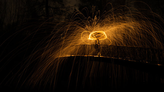 Steel wool spinning on a bridge  flying sparks