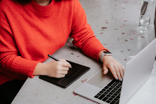 partial view of woman retouching on drawing tablet, professional web designer working on freelance sitting in cafe - Powered by Adobe