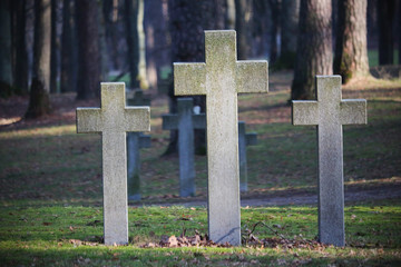 Three crosses standing on soldiers grave in light on sunny day