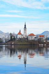 Fototapeta na wymiar Lake Bled Slovenia. Beautiful mountain lake with small Pilgrimage Church. Most famous Slovenian lake and island Bled with Pilgrimage Church of the Assumption of Maria and Bled Castle in background.
