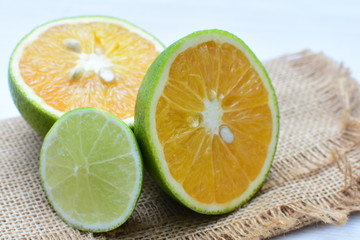Fototapeta na wymiar Tahiti lemons and whole and sliced oranges