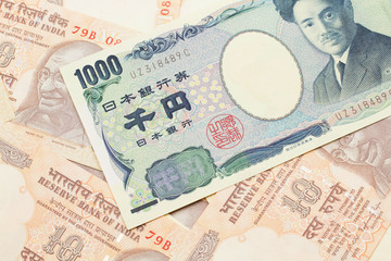 A one thousand Japanese yen bank note close up in macro with Indian ten rupee bank notes
