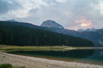Lake in Europe with forest and mountain in the background under a beautiful sky with clouds