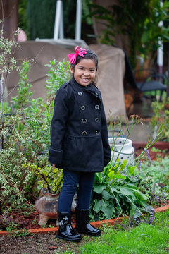 A Cute Girl Dressed For The Rainy Season, Stading In A Backyard With California Native Plants.