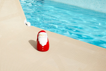 Santa Claus sunbathes at a beach resort. Christmas and New Year decoration. Travel or tourism concept