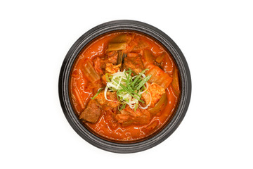 Isolated Kimchi soup in the black stone bowl in studio light on the white background.