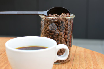 coffee beans, accompanied by cup of hot coffee