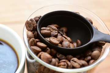 coffee beans, accompanied by cup of hot coffee