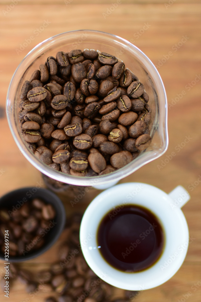 Wall mural coffee beans, accompanied by cup of hot coffee