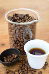 coffee beans, accompanied by cup of hot coffee