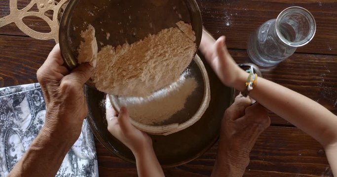 Top view preparing food. Cooking With Grandma. Beautiful Little Girl Learns How To Make Cookies.