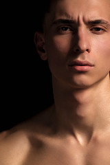 Naklejka premium Handsome wet sport sexy stripped guy portrait with waterdrops and smoke on isolated black background