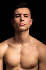 Handsome wet sport sexy stripped guy portrait with waterdrops and smoke on isolated black background