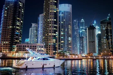 Fotobehang Big city lights. Night cityscape of Dubai marina embankment with skyscraper. © luengo_ua
