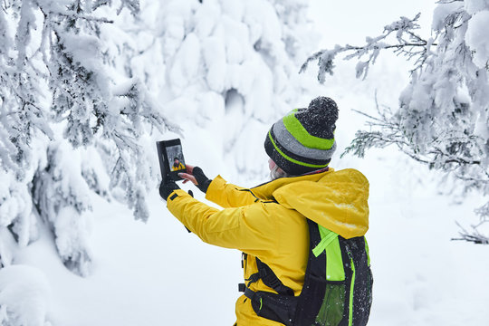 woman traveler in winter forest makes selfie