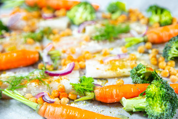 carrots, broccoli, chickpeas, fish fillets, onions and spices baked in the oven