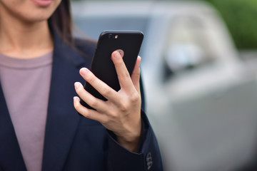 Business woman use smart phone at a car
