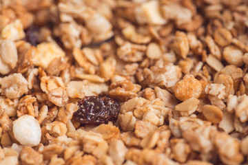 Useful and tasty muesli with nuts, rasins and flakes. Selective focus macro shot with very shallow depth of field. Healthy and vegetarian lifestyle