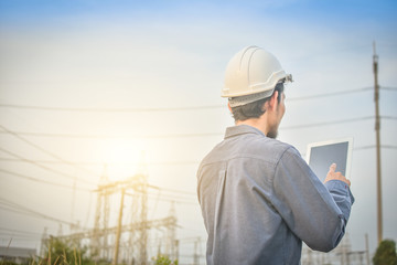 Electrical engineer uses a tablet to inspect Power plant network For power generation