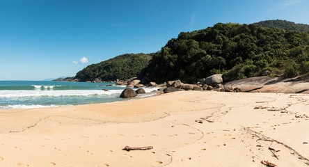 Obraz premium Panoramic view Beautiful Parnaioca beach with crystal clear blue water and stones, deserted tropical beach in the sunny Coast of Rio de Janeiro, Ilha Grande in the city of Agnra dos Reis, Brazil